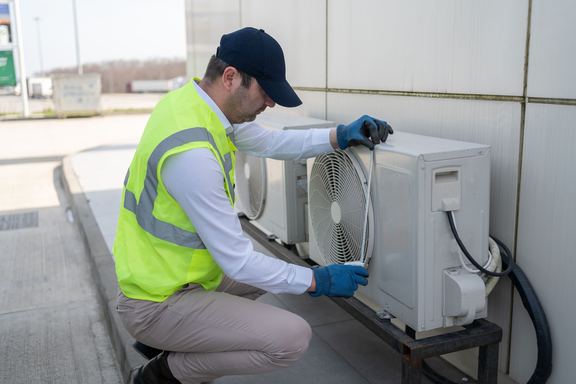 Man Doing Maintenance On Outdoor Air Conditioning Unit